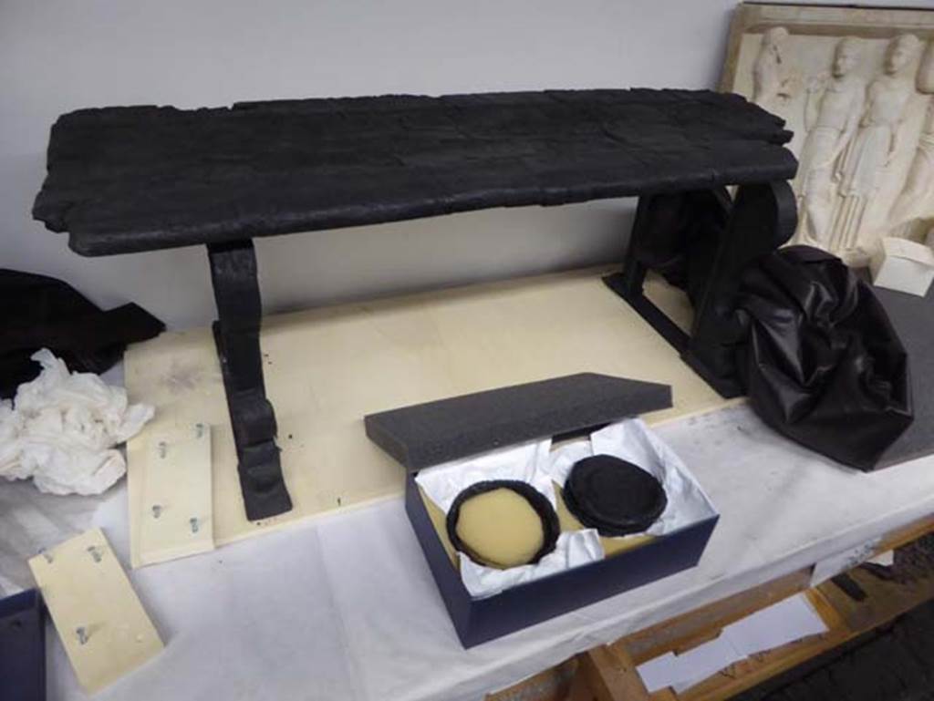 Decumanus Maximus, Herculaneum. September 2016. At rear, carbonised wooden bench/long seat with moulded front legs.
Photo courtesy of Michael Binns.
According to De Carolis, as above photo, this bench was found in Decumanus Maximus.
See De Carolis, E. (2007). Il mobile a Pompei ed Ercolano, letti tavoli sedie e armadi. Rome, “L’ERMA” di Bretschneider, (p. 131, fig.95).